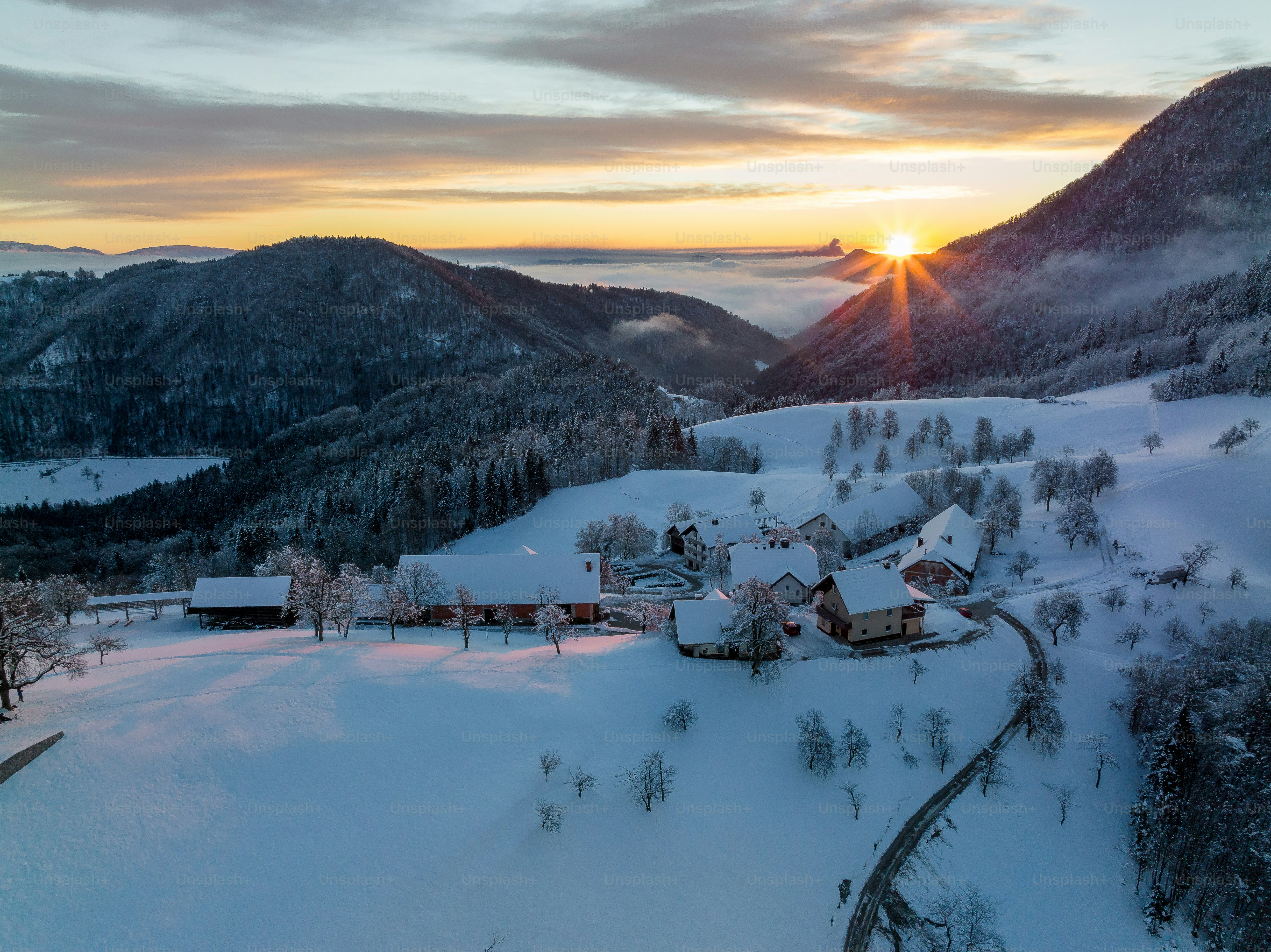 El sol se está poniendo sobre un pueblo nevado de montaña