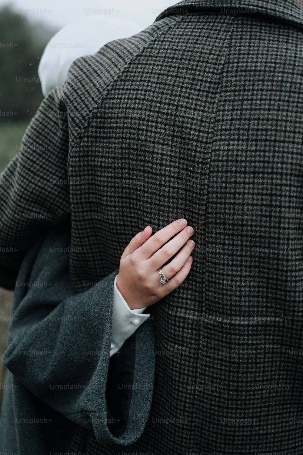 a man in a suit and tie holding his hand on his shoulder