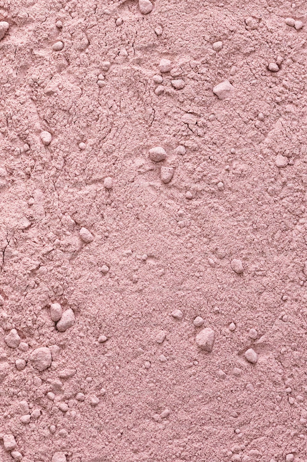 작은 바위가 있는 분홍색 벽의 클로즈업
