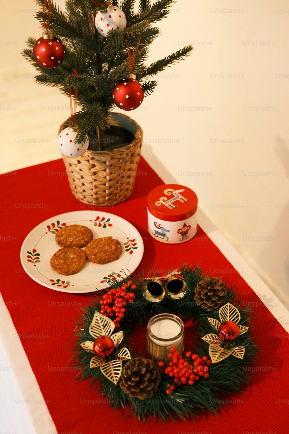a table topped with a plate of cookies next to a christmas tree