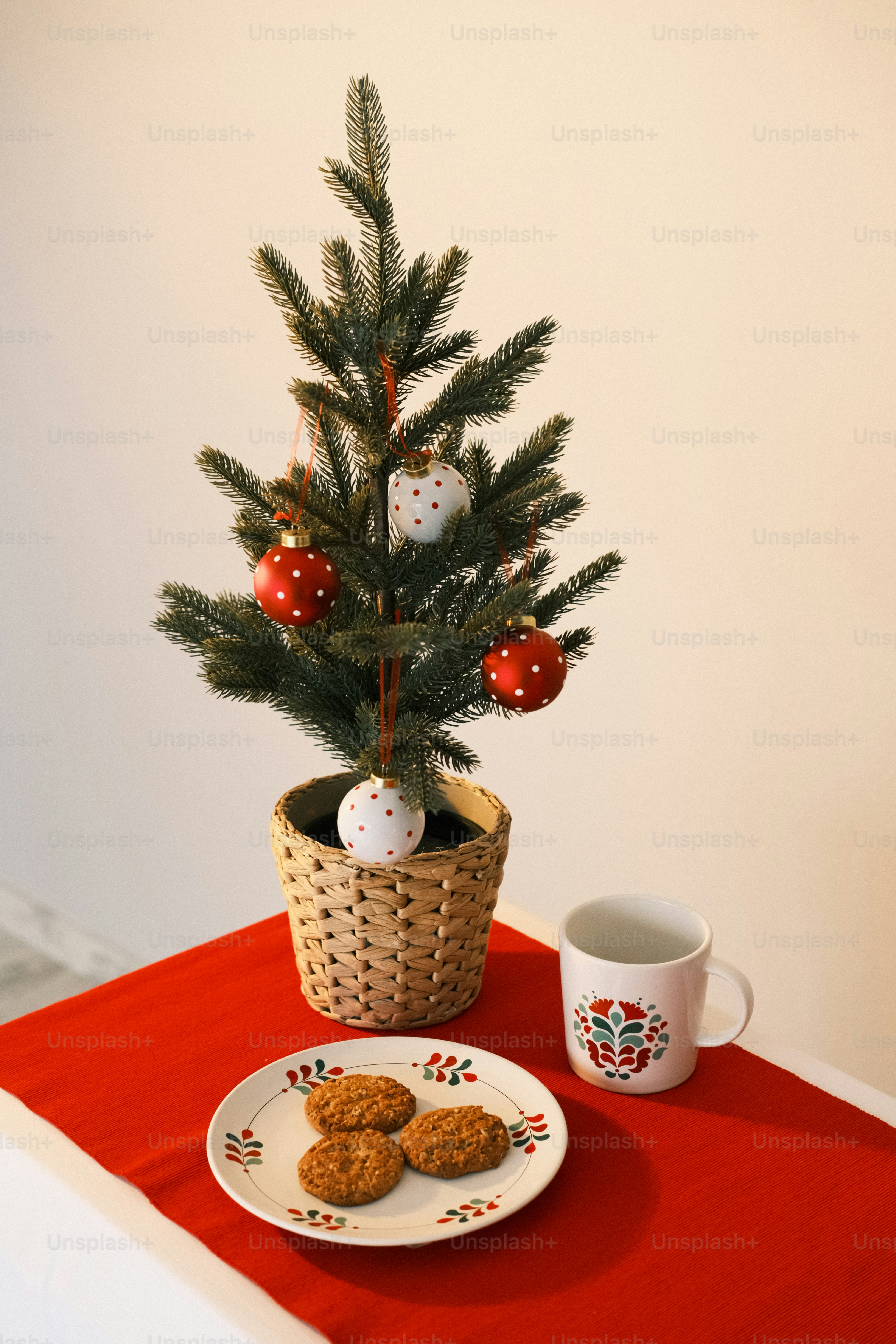 クッキーの皿の隣のバスケットに入った小さなクリスマスツリー