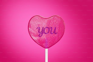 a pink lollipop with the word you written on it