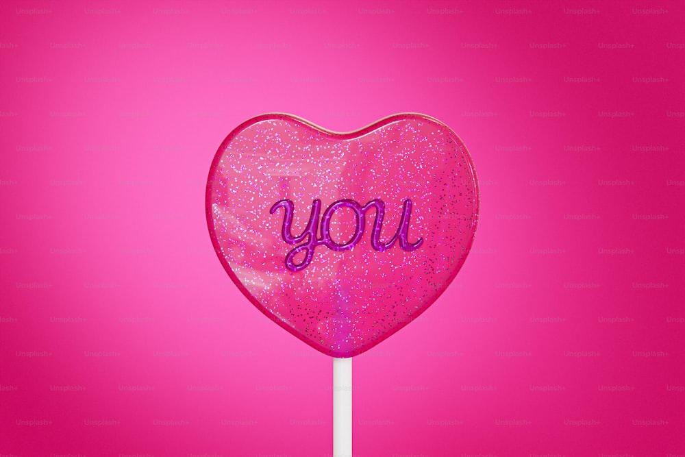a pink lollipop with the word you written on it