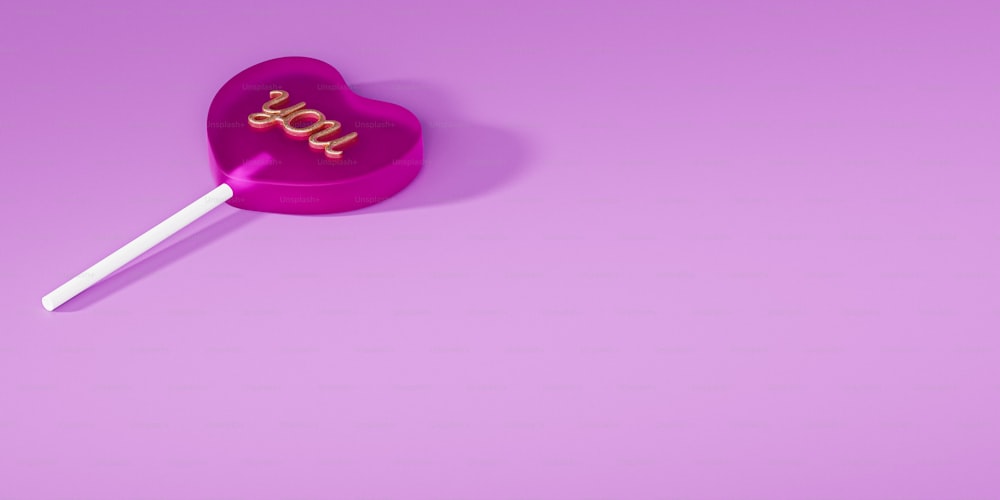 Una piruleta rosa con la palabra amor en ella