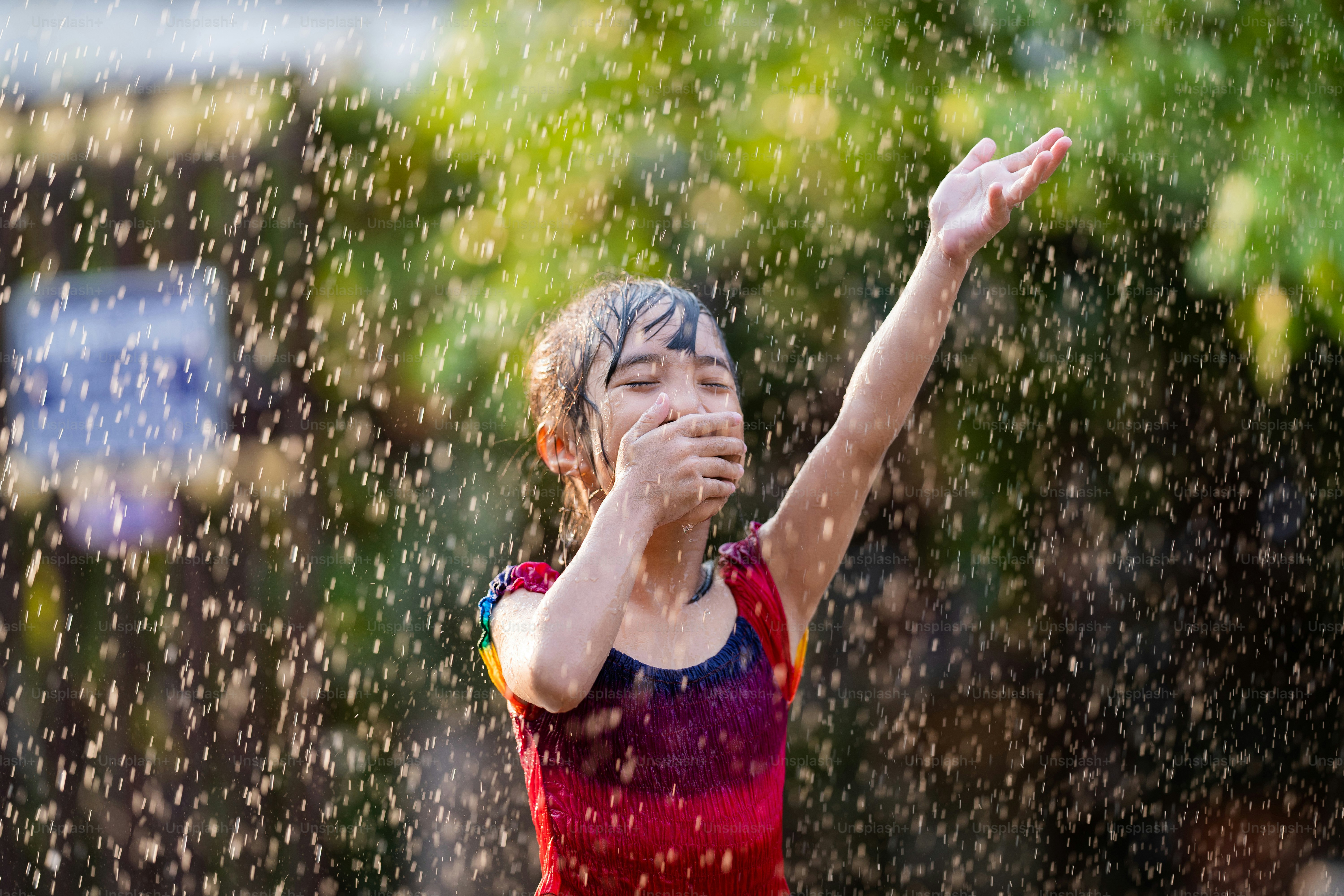 Asian children playing in the rain are happy.