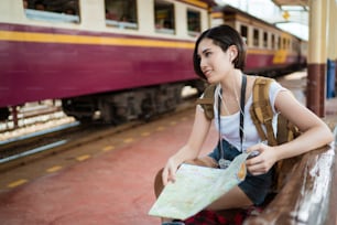 기차에 여자 여행자는 광경을 보러 갔다.그녀는지도를 읽고있다