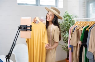 Asian woman selling vintage clothes, she is live on social media.