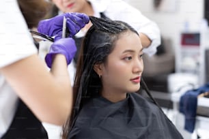 Le estetiste asiatiche stanno tingendo i capelli e facendo i capelli per customers.in salone di bellezza