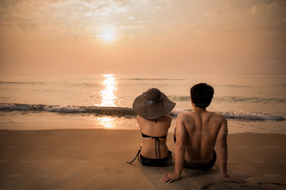Lovers watching the sunset at the beach.