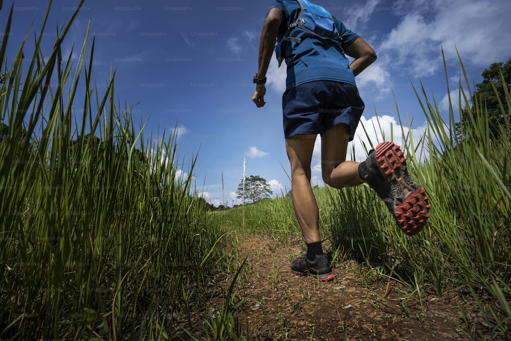 アジアの男性がトレイルを走っている 自然の道で