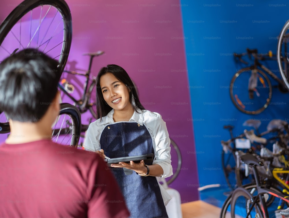 Bicycle salesman is advising customers to choose bikes.