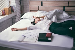 비즈니스 여성 그녀는 스트레스를 느꼈다 퇴근 후 그녀는 침대에서 휴식을 취했습니다.
