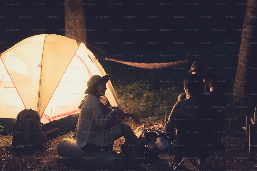 친구들은 밤에 숲에서 캠핑을하고 있습니다.