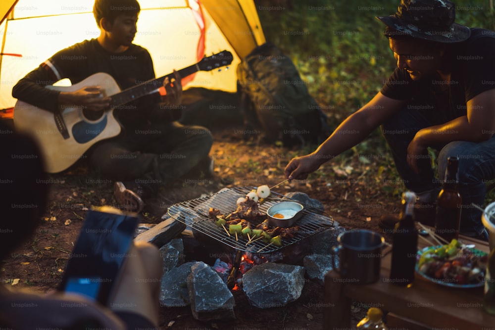 Grupo de amigos está acampando E churrasco