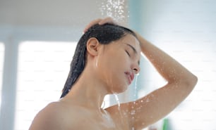 Mulher asiática Ela toma um banho e lava o cabelo no banheiro