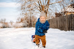 a little boy that is standing in the snow