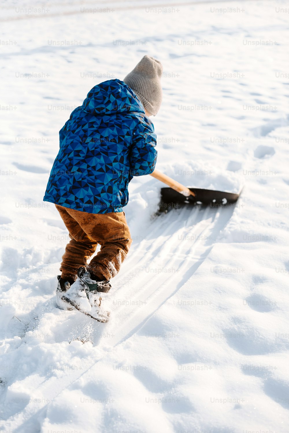 Un niño pequeño está paleando a través de la nieve