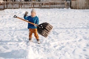 a young boy holding a hockey stick in the snow