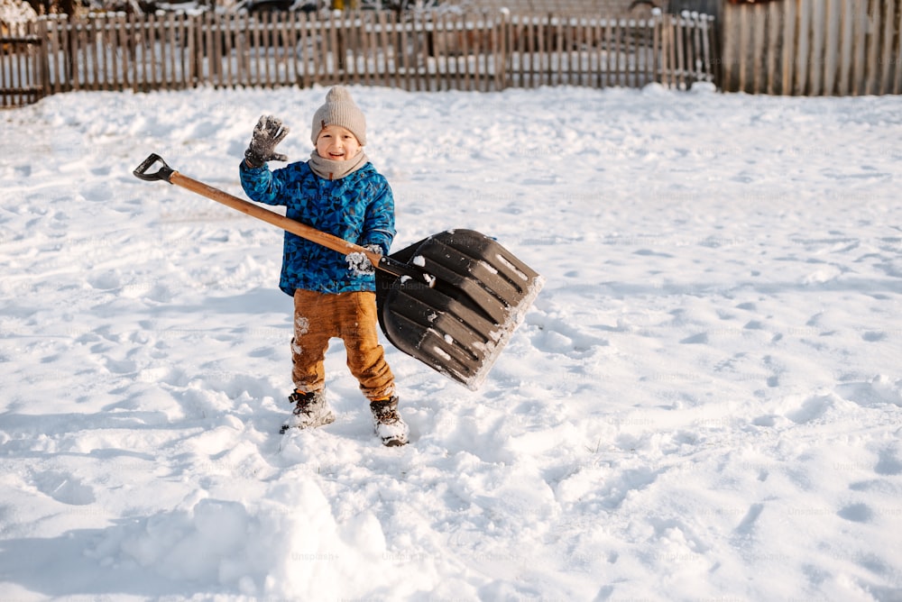 a young boy holding a hockey stick in the snow