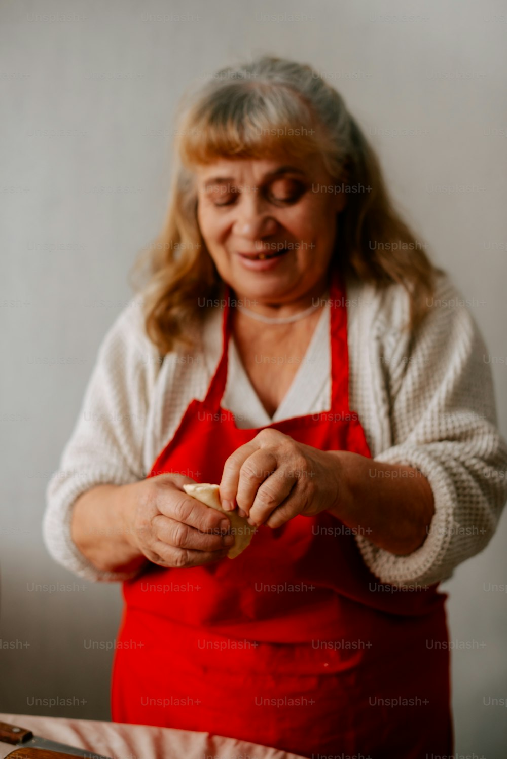 uma mulher em um avental preparando comida em uma mesa