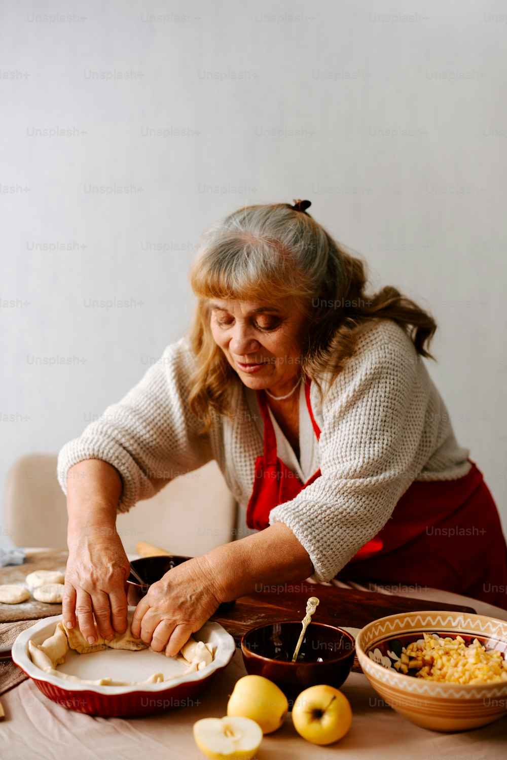 a woman in an apron preparing food on a table