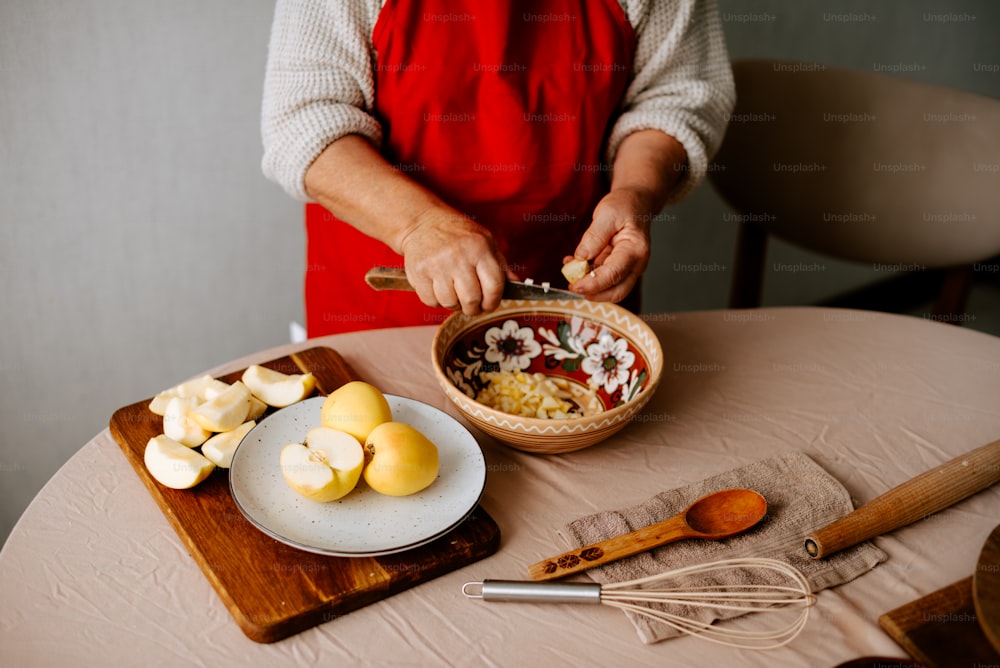 a woman in an apron is preparing food on a table