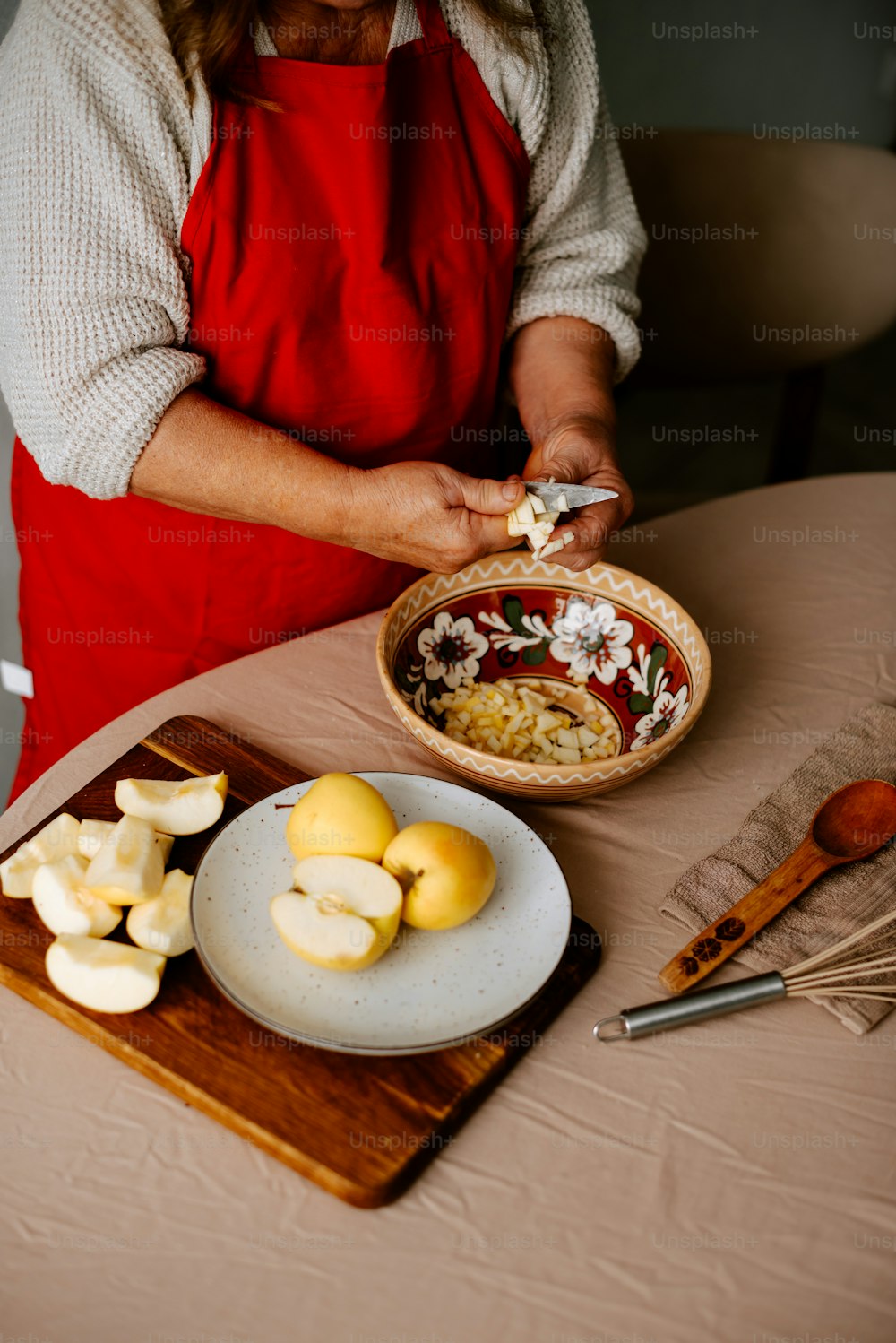 Eine Frau in roter Schürze bereitet Essen auf einem Tisch zu