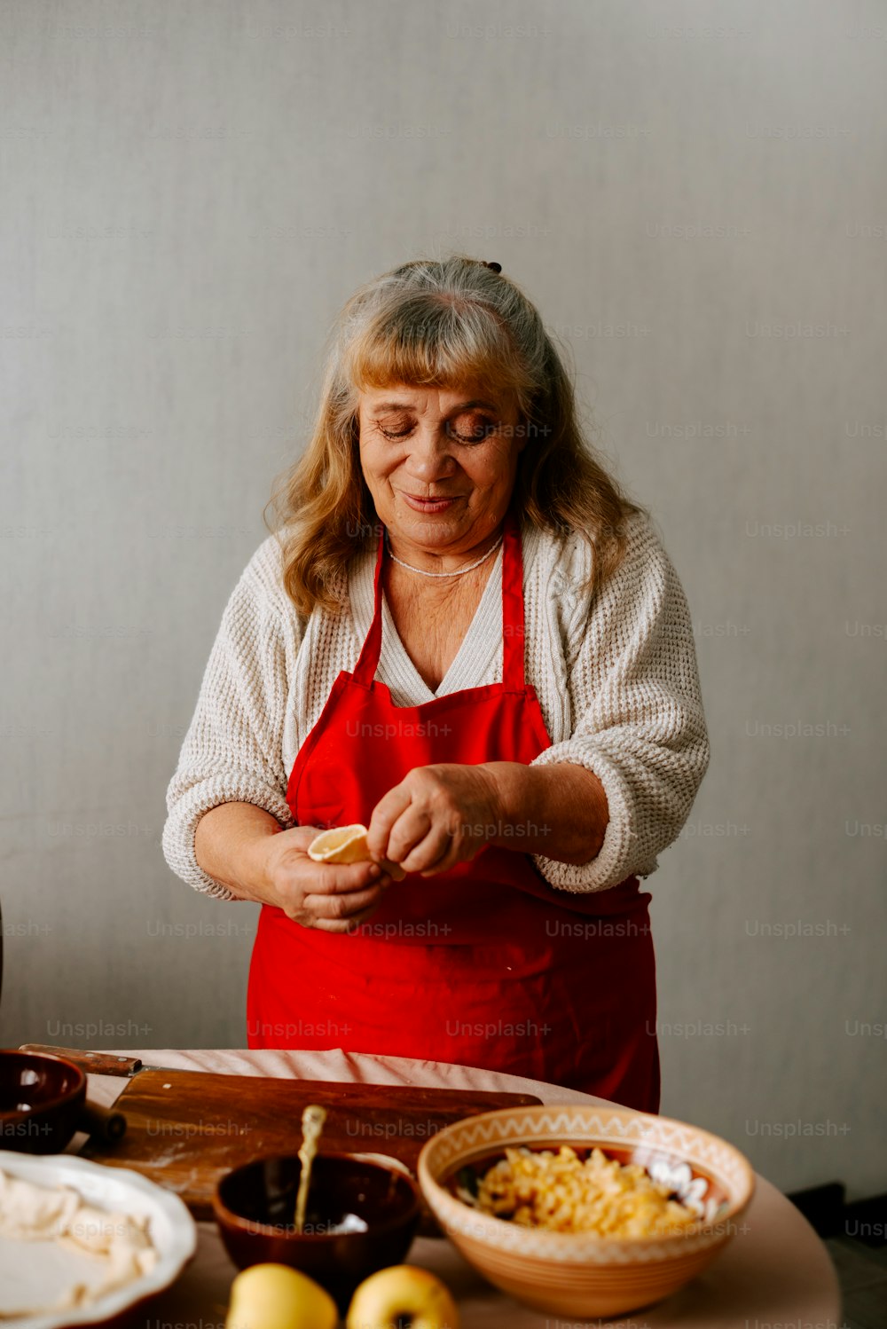 uma mulher em um avental preparando comida em uma mesa
