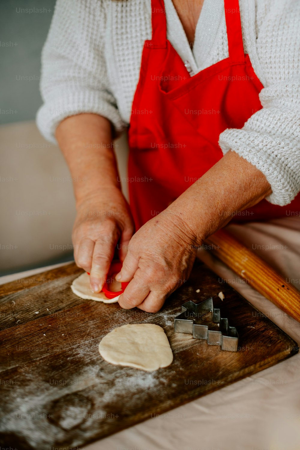 a woman in an apron is kneading dough on a board