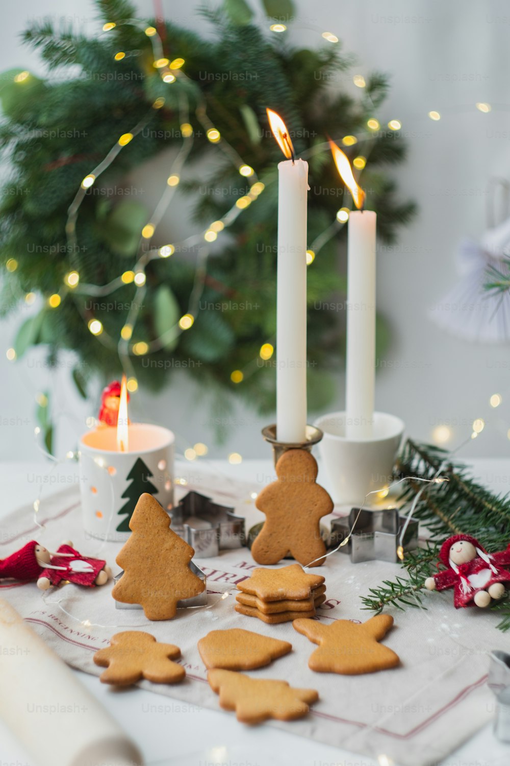 uma mesa coberta com muitos biscoitos ao lado de uma vela acesa