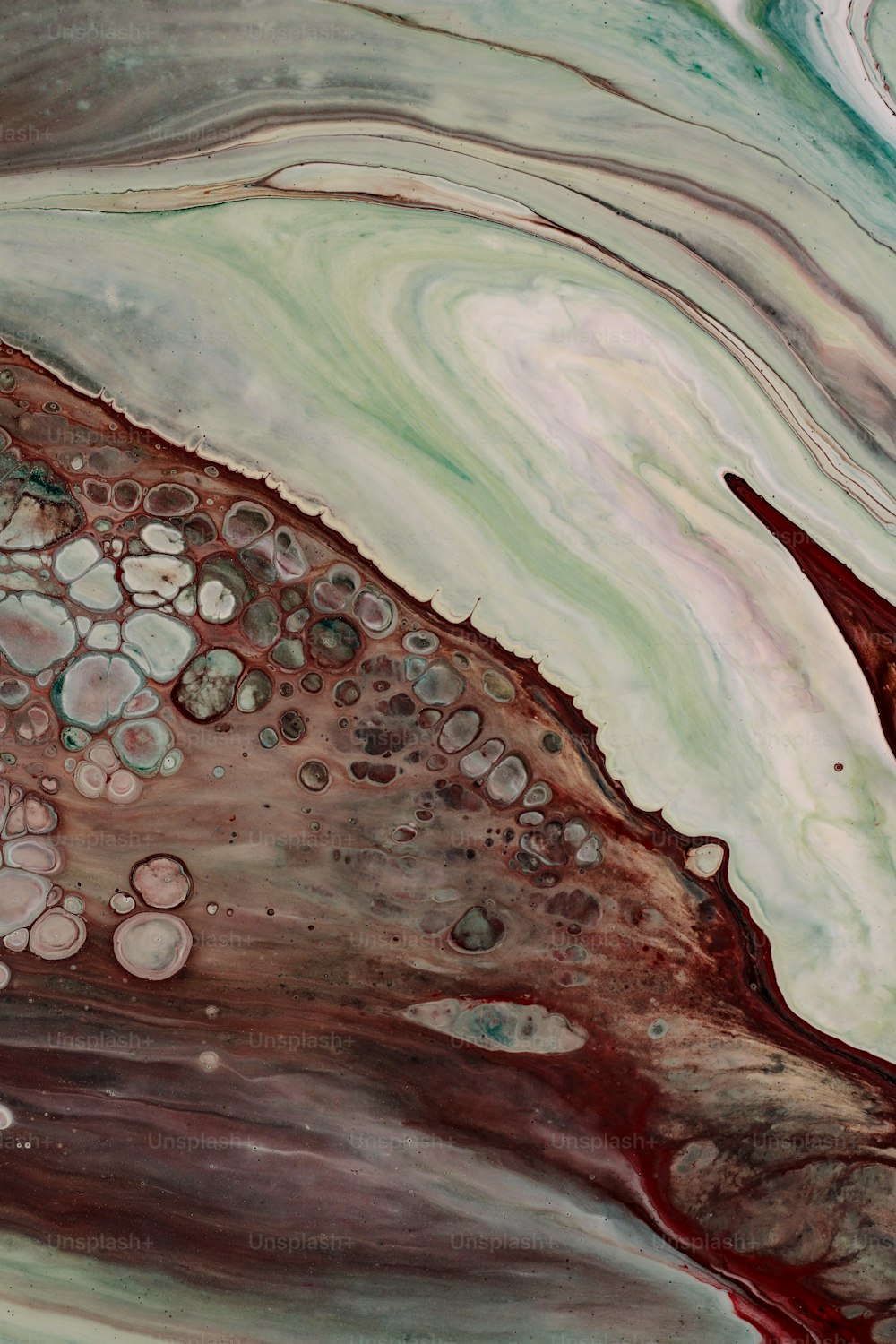 a close up of an abstract painting with red and green colors