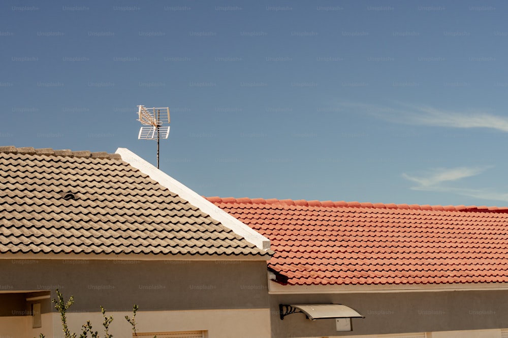 a house with a red tiled roof and a wind vane on top of it