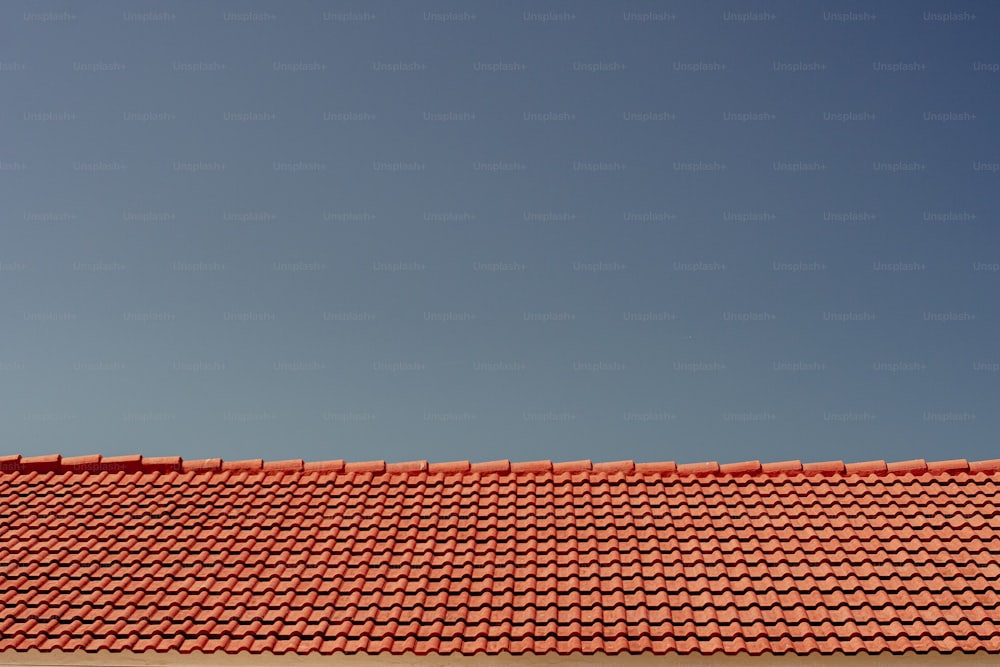 a red roof with a blue sky in the background
