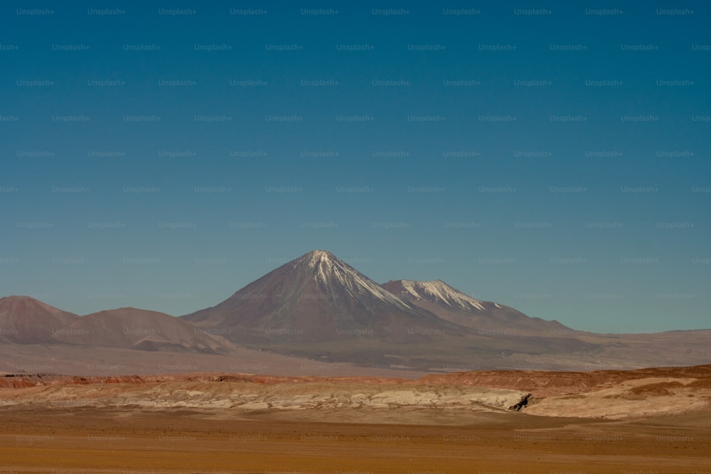 a large mountain in the middle of a desert