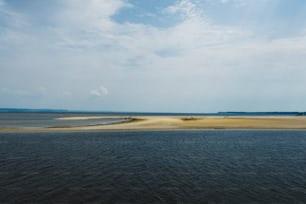una gran masa de agua sentada junto a una playa de arena
