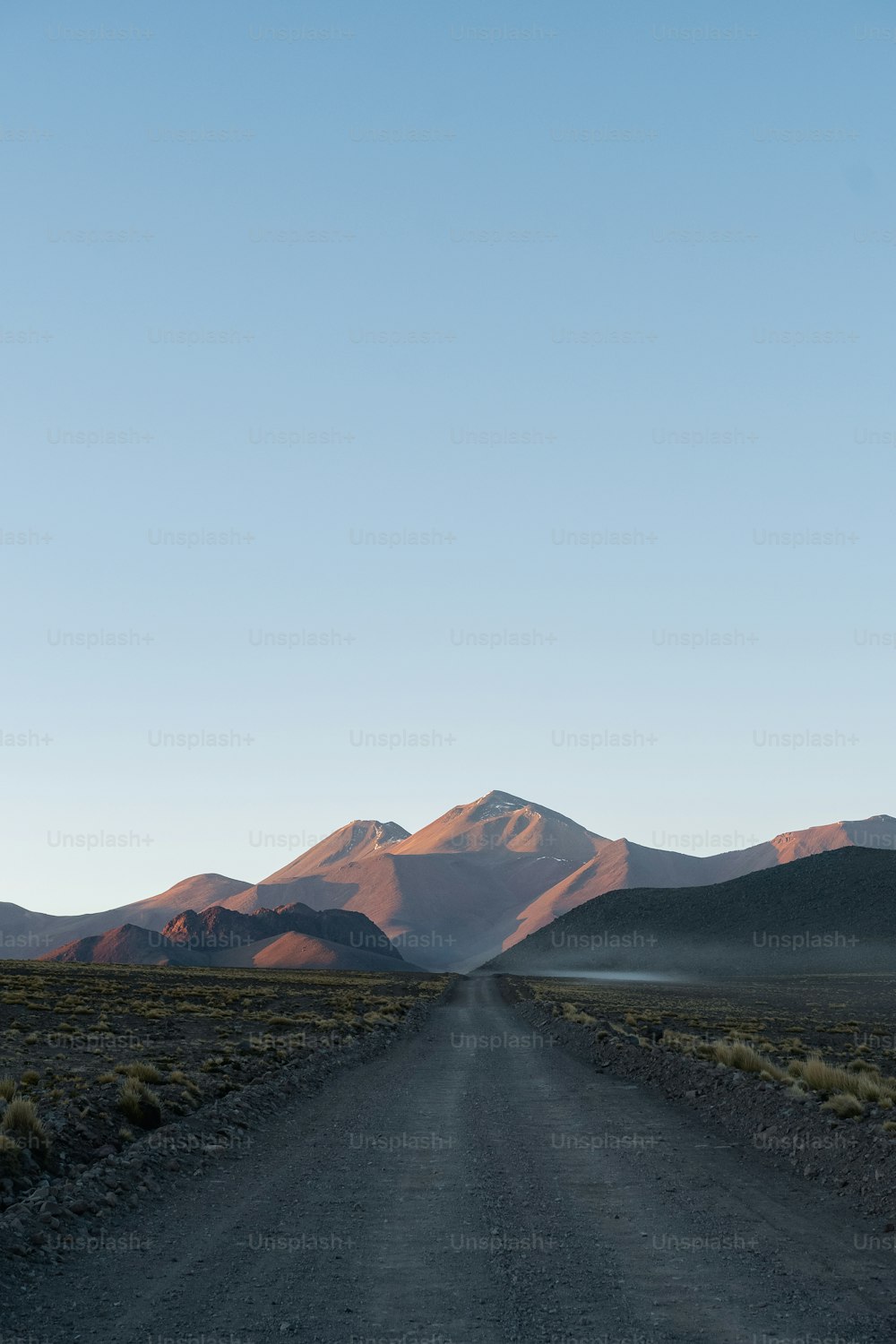 a dirt road with mountains in the background