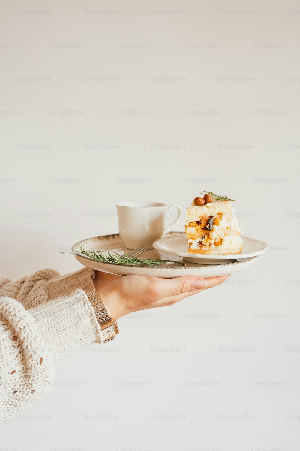 a person holding a plate with a piece of cake on it