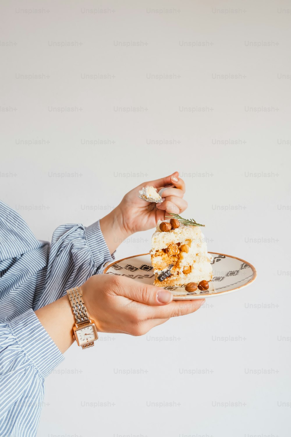 a woman holding a piece of cake on a plate