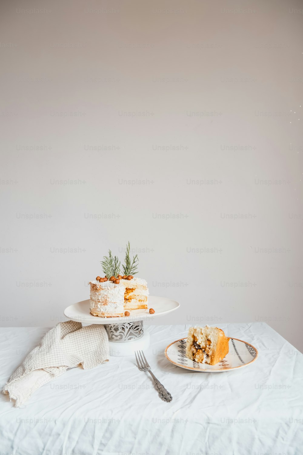a white table topped with a cake and a fork