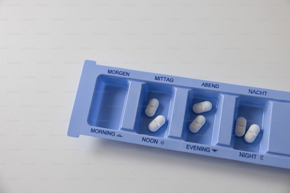 Un porte-pilules bleu avec des pilules dedans