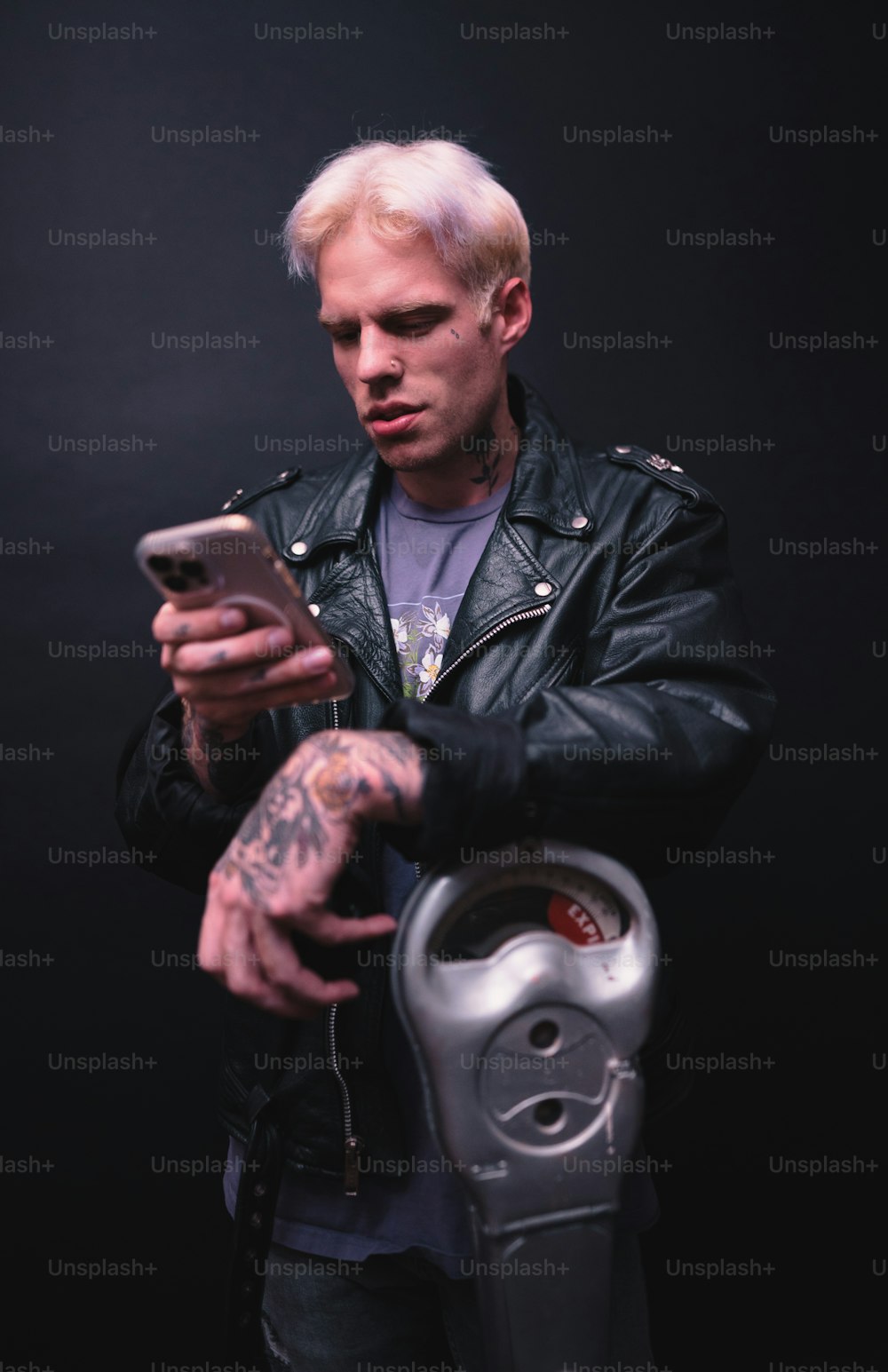 a man in a leather jacket holding a cell phone