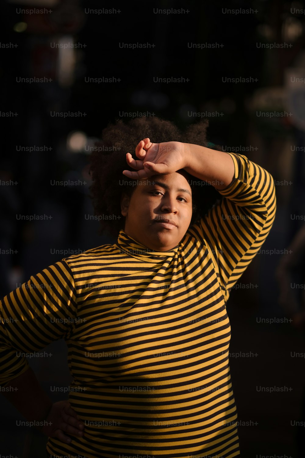 Una donna in una camicia a righe gialle e nere