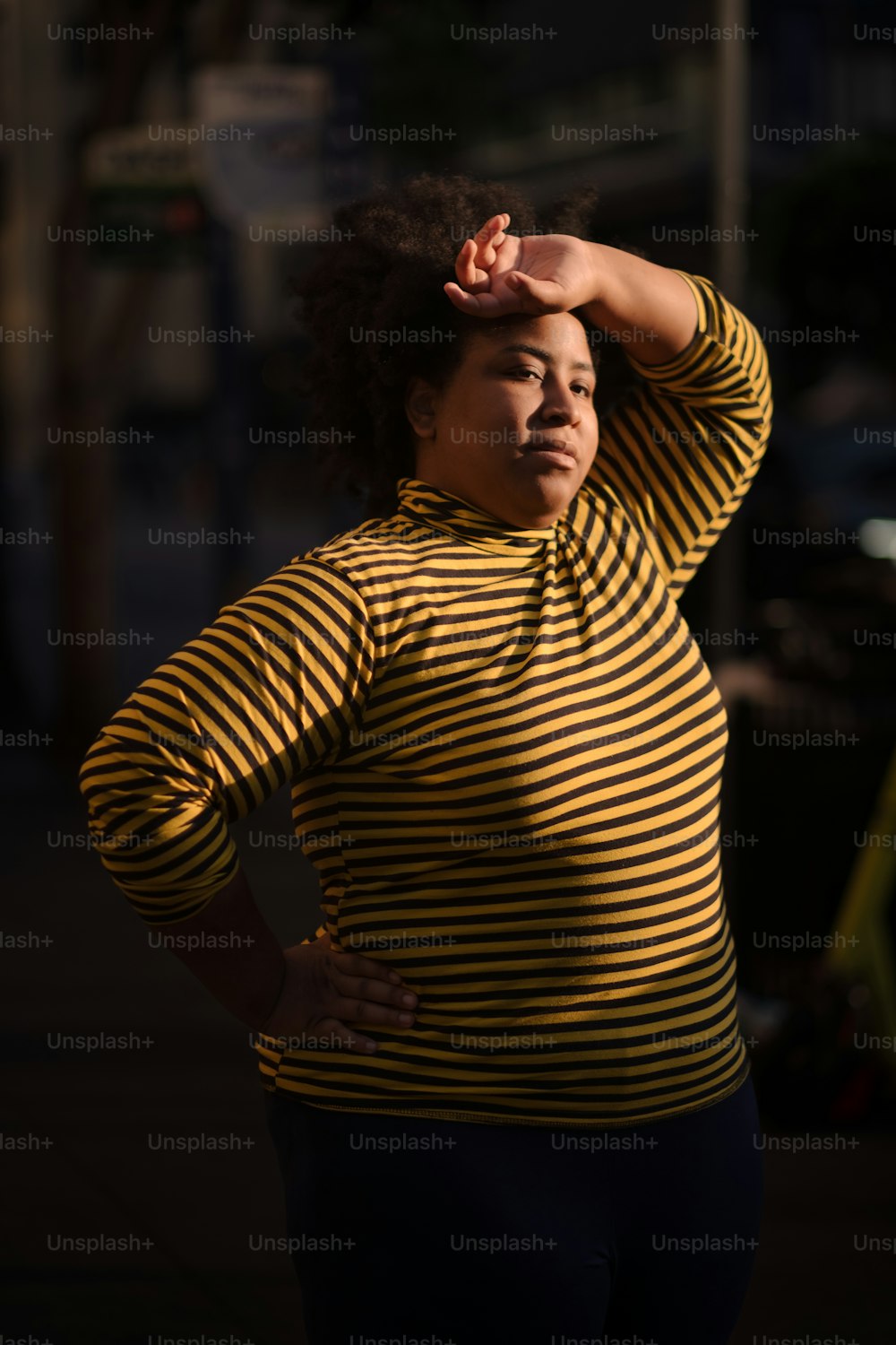 Una donna in una camicia a righe gialle e nere