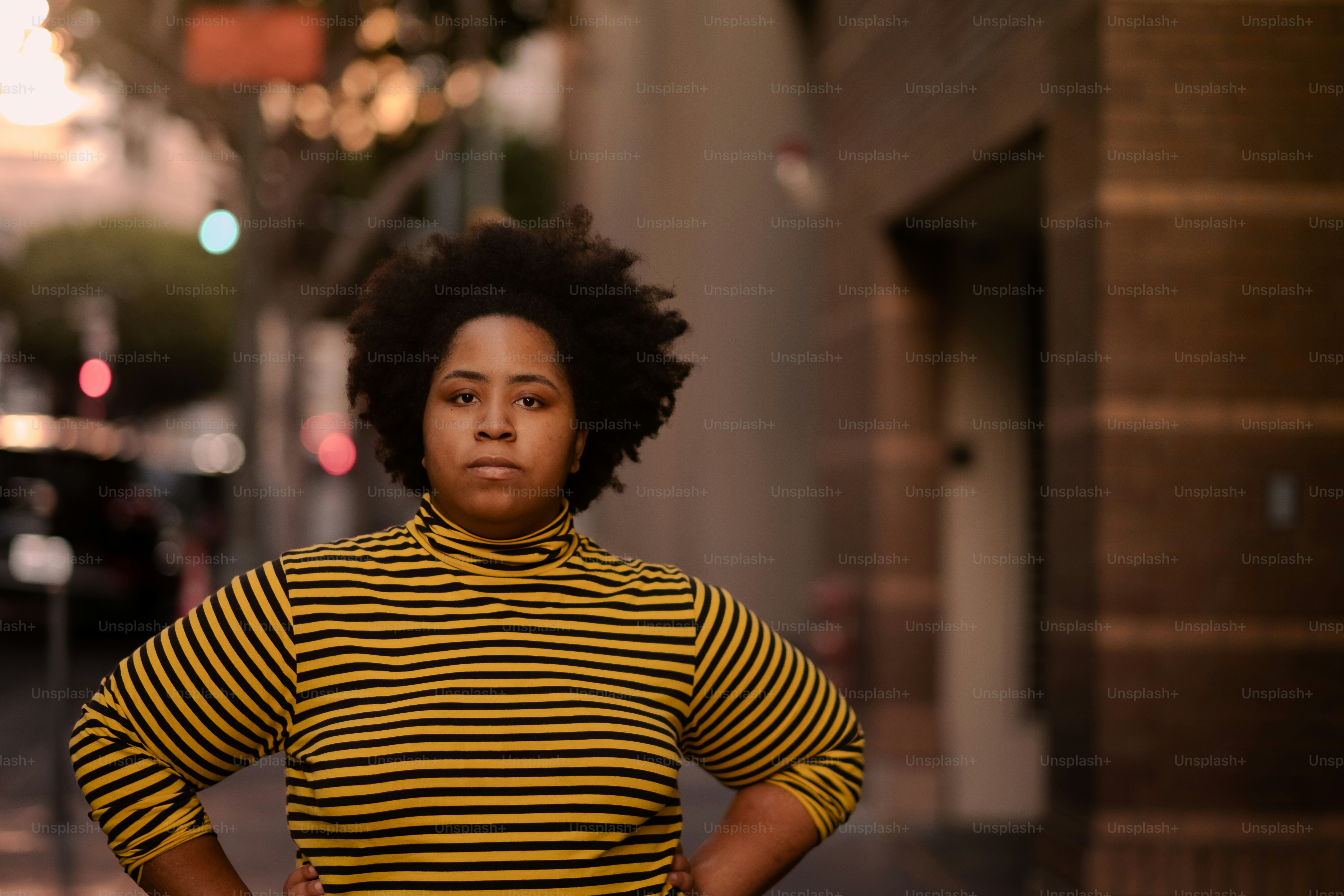 A woman leaning against a wall with her hands on her hips photo – Woman ...
