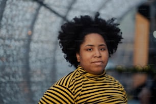 a woman wearing a yellow and black striped shirt