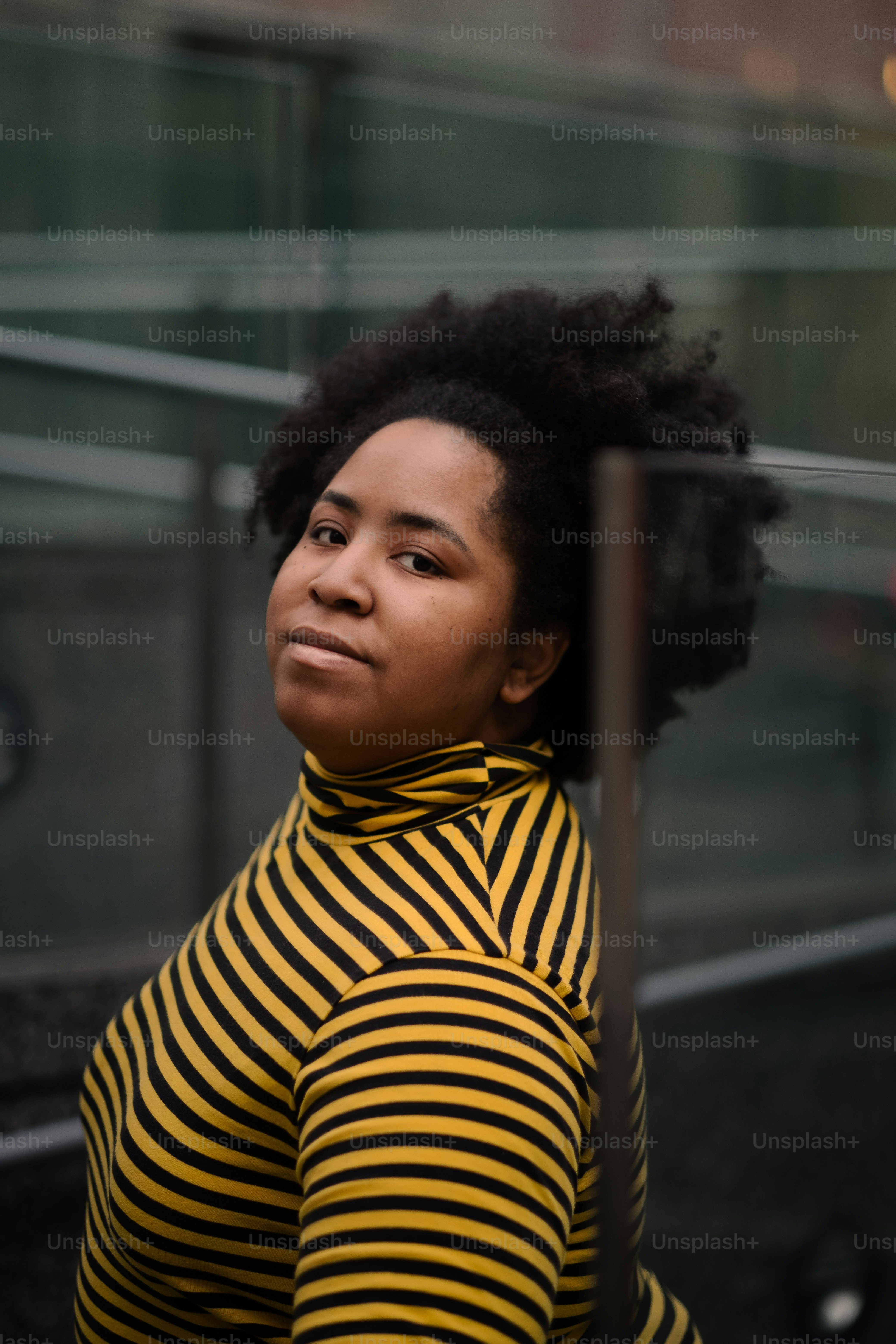 A woman with black hair standing in front of a building photo ...