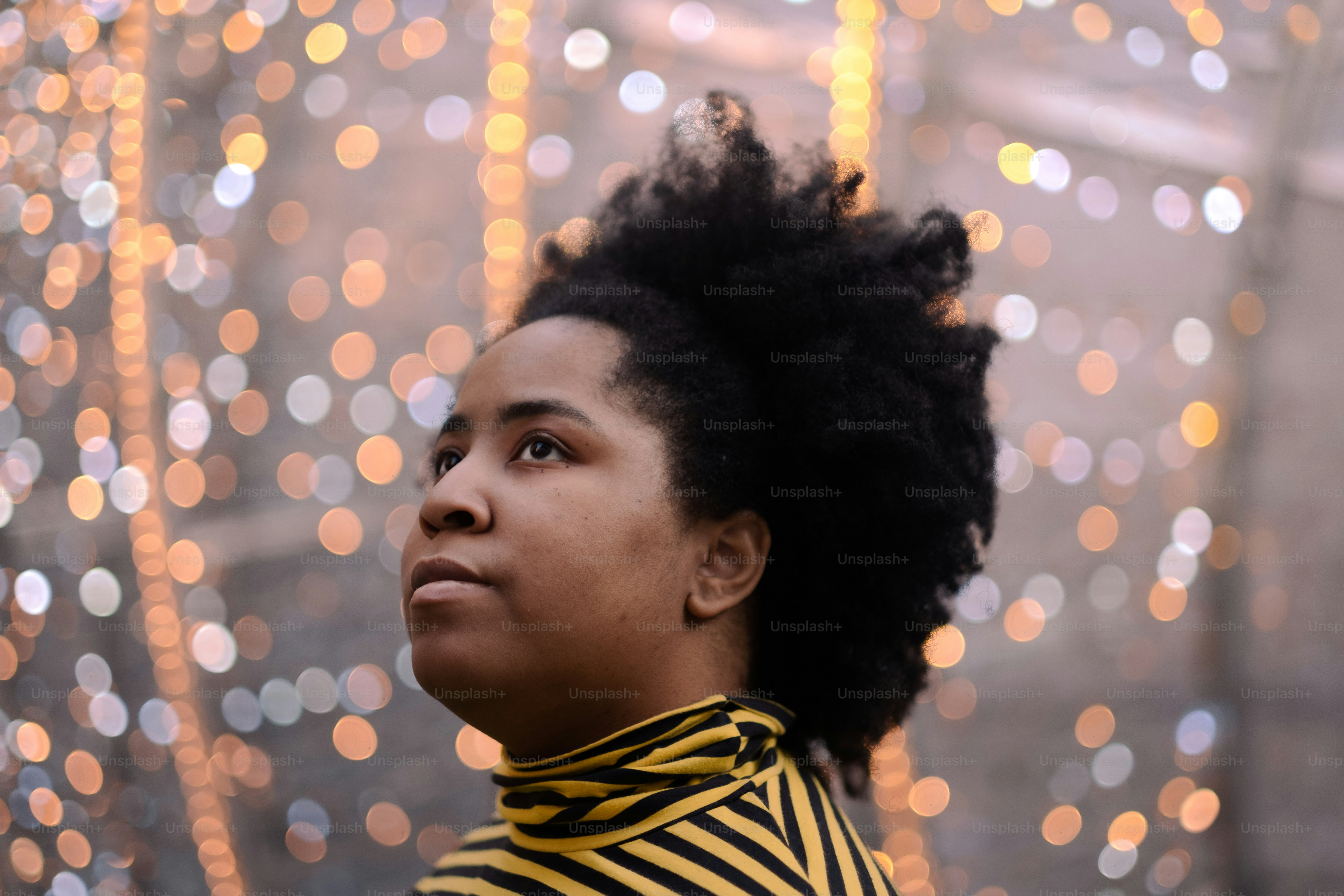 une femme aux cheveux noirs portant une chemise rayée jaune et noire