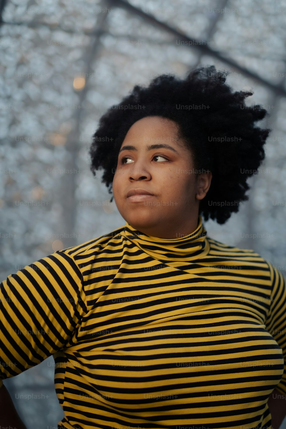 a woman wearing a yellow and black striped shirt