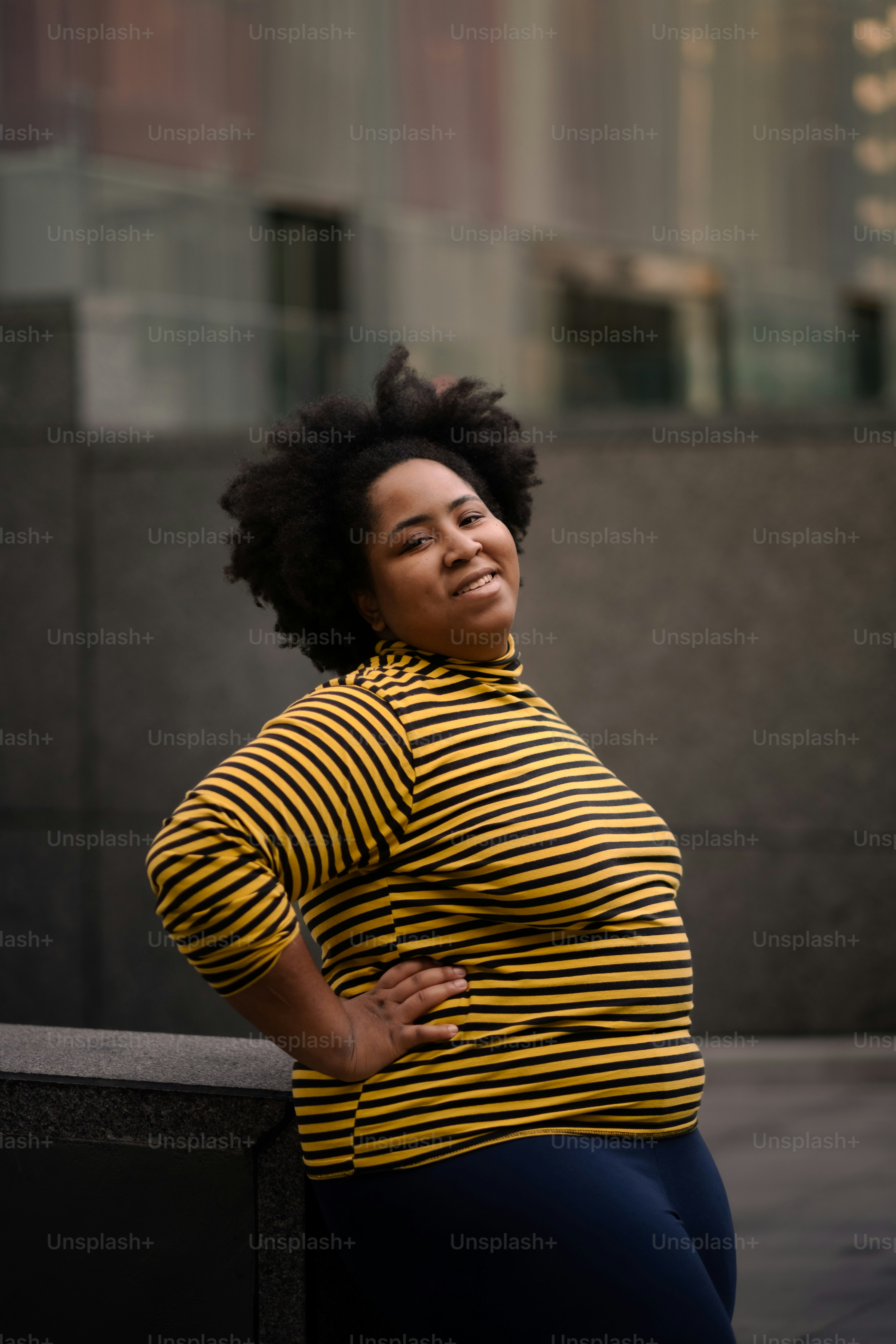 A woman leaning against a wall with her hands on her hips photo – Woman ...