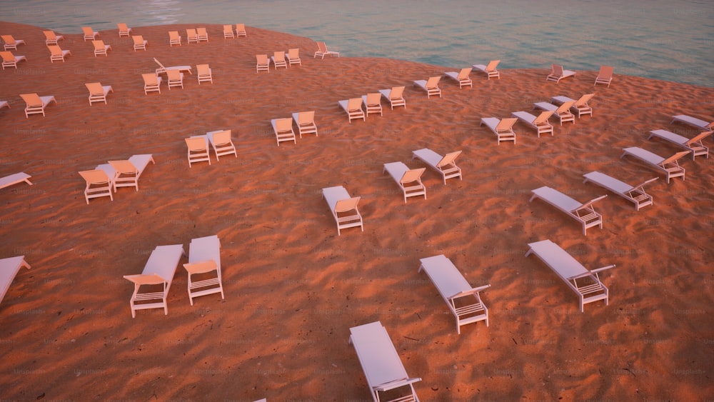 un mucchio di sedie che sono sedute nella sabbia